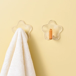 Details von sternförmigen Acryl-Klebehaken mit goldfarbenem Metallhaken und Handtuch