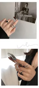 Detail view of S925 sterling silver stacked rings with black enamel on a hand