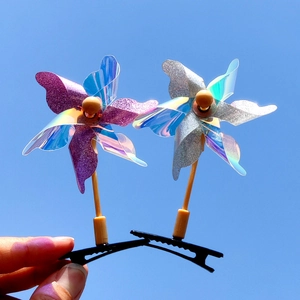 Pinces à cheveux moulin à vent pailleté avec tige en bois sur fond de ciel bleu clair