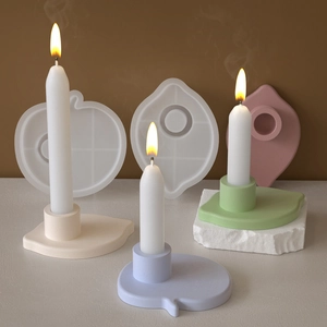 Macro detail of silicone molds and finished star-shaped resin candle holders on a stone surface