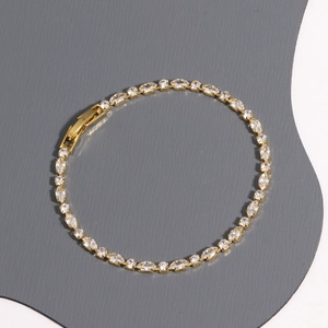 Close-up of gold tennis bracelet with marquise zircons and secure folding clasp