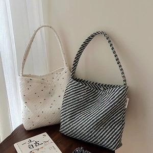 Dettaglio di borse tote intrecciate con texture in maglia puntinata e fibbia magnetica