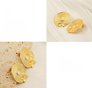 Macro detail of gold bow straw hat earrings showing fine woven texture and polished finish