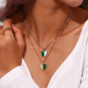 Elegant gold and silver heart necklace with green and white shell inlay on female model