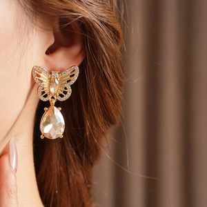 Gros plan de boucles d'oreilles papillon vintage avec cristaux et pendentifs gouttes