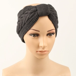 Detail of dark grey cable knit headband with bow on a mannequin for winter warmth