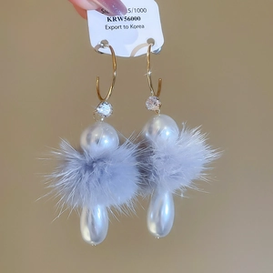 Détail de boucles d'oreilles perles avec pompon en fourrure grise et zircon