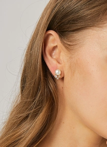Close-up of elegant pearl and zircon stud earrings featuring a triangular crystal cluster