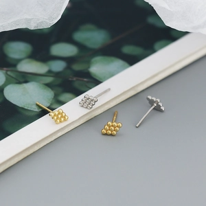 Detailed view of silver and gold geometric square stud earrings with nine-bead design