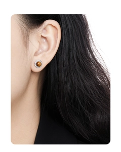 Macro shot of halo silver stud earring with round brown tiger eye stone on model