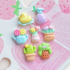 Detailed view of mini resin duck and flower pot accessories for DIY craft on pink background