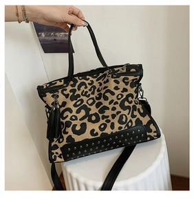 Detail of leopard print handbag with black leather trim, tassels, and metal rivets