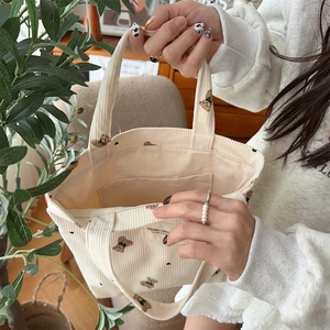 Detailed interior of a beige corduroy tote bag showing spacious inner lining and pockets