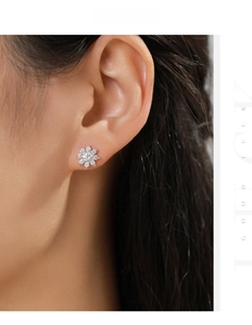 Close-up of sparkling snowflake moissanite stud earring worn on a model's ear