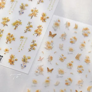 Detail von floralen Nagelstickern mit goldenen Osmanthus-Designs und chinesischem Stil