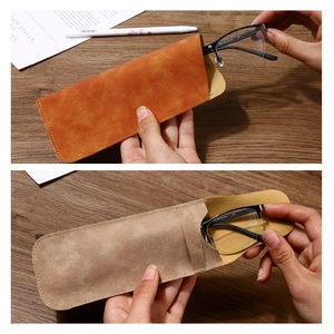 Portable soft leather glasses case for sunglasses in tan and beige on a wooden desk