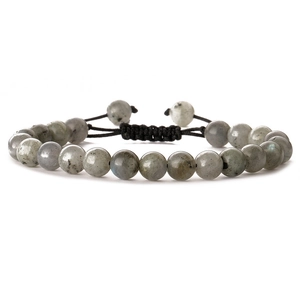 Macro shot of grey natural stone beads with detailed texture and black braided cord