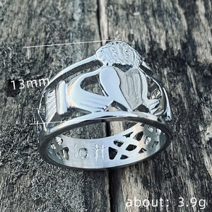 Bague Claddagh classique en argent avec mains cœur et couronne sur fond en bois sombre