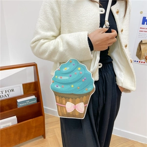 Cute cupcake shaped crossbody bag with blue frosting and pink bow worn by model