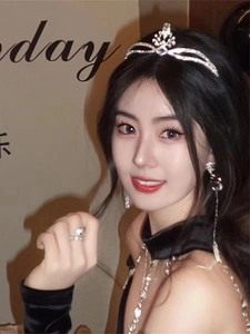 Close-up of a bride wearing a silver tiara with matching earrings and a ring set