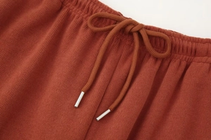 Nahaufnahme des elastischen Bunds der karamellfarbenen Strickhose mit Kordelzug