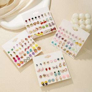 Flat lay of multiple colorful enamel stud earring sets with cute animal and fruit designs
