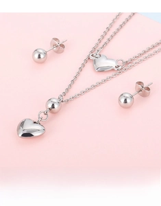 Detail of silver double-layered heart necklace and matching round stud earrings set