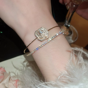 Detail of elegant gold double-layer zircon flower open bracelets on a female wrist