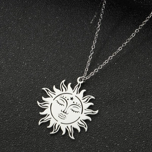 Detailed close-up of retro sun face pendant necklace in silver finish on black background