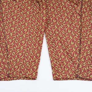 Detailed close-up of red and yellow Paisley print fabric on trousers with high precision
