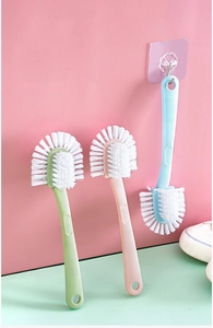 Detail of multi-purpose long handle shoe brushes in blue, green, and pink colors
