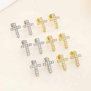 Macro shot of cross stud earrings with sparkling rhinestones in gold and silver finishes