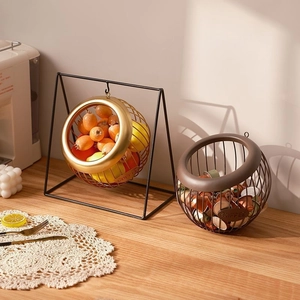 Golden hanging wire fruit basket and brown snack bowl for coffee capsule storage
