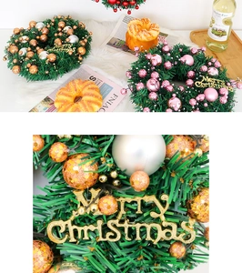 Detail of Christmas wreath with pine needles, festive glitter balls and Merry Christmas sign