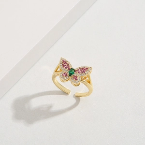 Detailed macro view of gold-plated brass ring with pink and white zircon butterfly