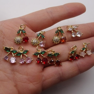 Sparkling cherry pendants with micro-set zircon crystals held in palm to show real size
