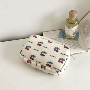 Large cherry print cream cosmetic bag with Les grenadas text and secure zip closure