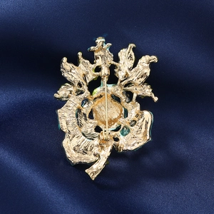 Vintage golden rose brooch with rhinestones and enamel on elegant blue silk background