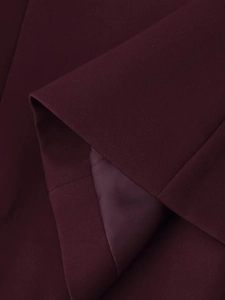 Détail du tissu de costume bordeaux montrant la texture sergé et la doublure lisse