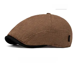 Close-up of coffee brown waffle knit texture on a retro flat cap with black brim detail