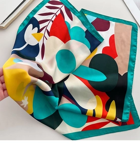 Detail of floral geometric printed silk scarf showing its smooth satin texture and drape
