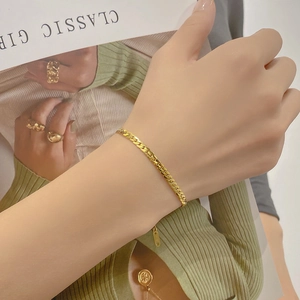 Classic minimalist gold Cuban link bracelet for women styled on a model's wrist