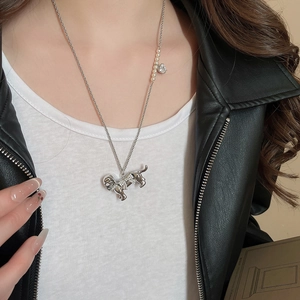 Detail of silver puppy pendant necklace featuring micro-set zircons and elegant pearls