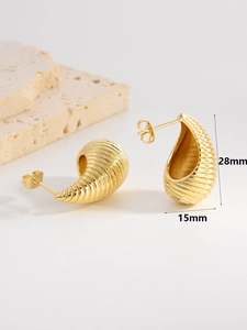 Polished 18K gold teardrop earrings with spiral texture on white stone background