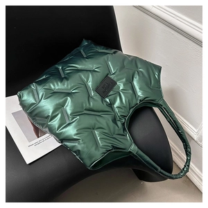 Detail der grünen gesteppten Puffer-Tasche mit Glanzeffekt und modischem Markenetikett