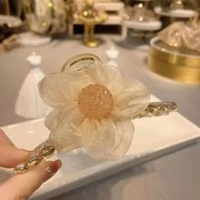 Detailed view of semi-transparent woven flower hair claw clip with crystal bead center