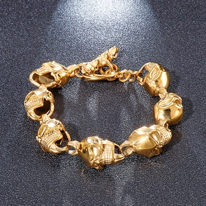 Polished gold-tone titanium steel bracelet featuring a sequence of skull-shaped links