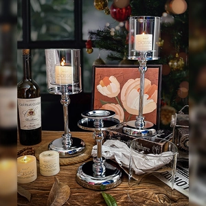 Nordic silver metal candle holders with glass covers set in a cozy home decor scene