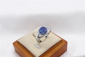 Detailed 45-degree angle of a round lapis lazuli stone set in a polished silver ring band