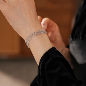 Close-up of silver lace hollow geometric bracelet on wrist with fine bead weaving detail
